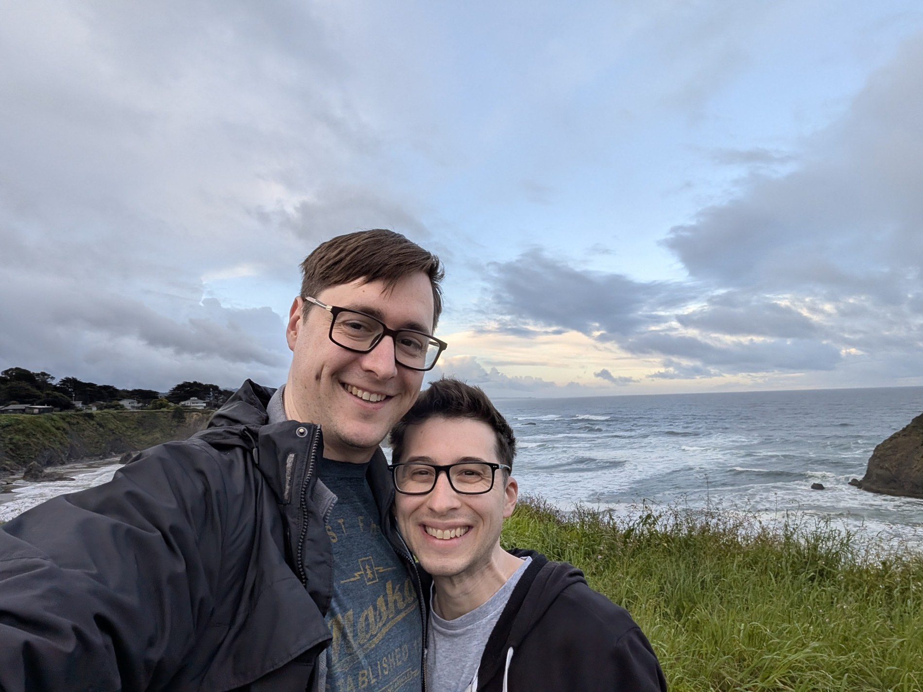 Aaron and Peter on a grassy path beside the ocean